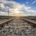 View of train tracks stretching into the horizon during sunset with a partly cloudy sky